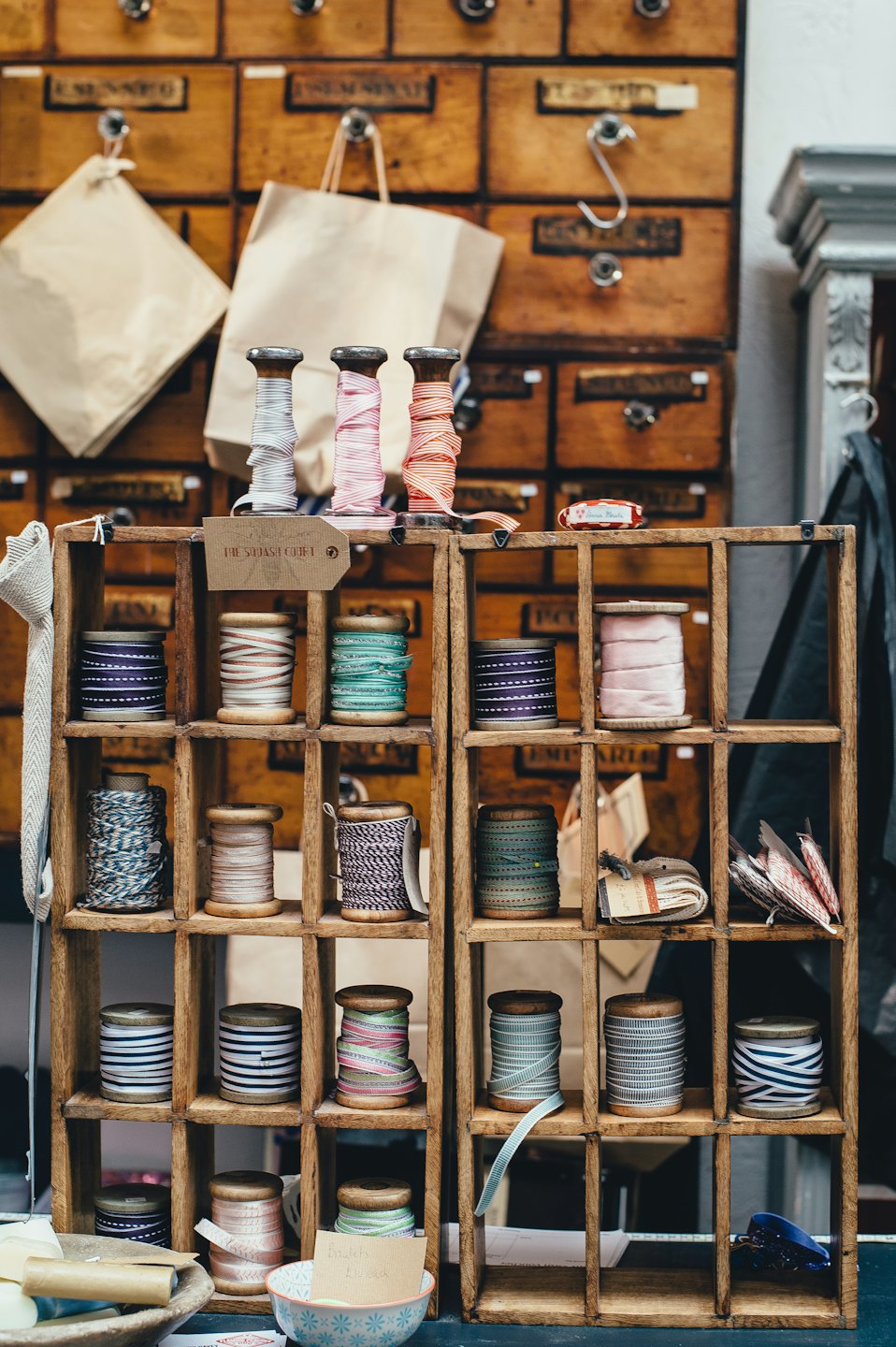 Wooden craft rack with colorful ribbons, yarns, and cords.